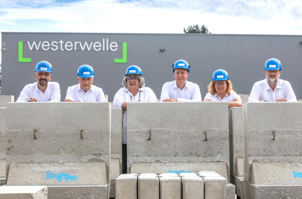 [Translate to Polski:] Gruppenbild hinter Betonteilen vor dem Firmengebäude