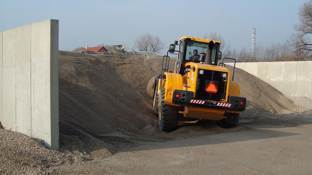 [Translate to Polski:] Fahrsilo mit Kies und Bagger