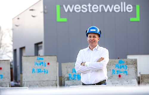 Geschäftsführer Kai-Uwe Westerwelle steht mit Helm vor dem Firmengebäude