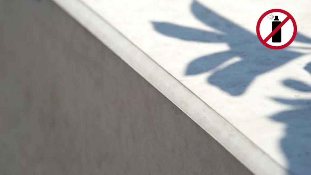 Betonowa krawędź z cieniem liści, ikona przekreślonej puszki sprayu