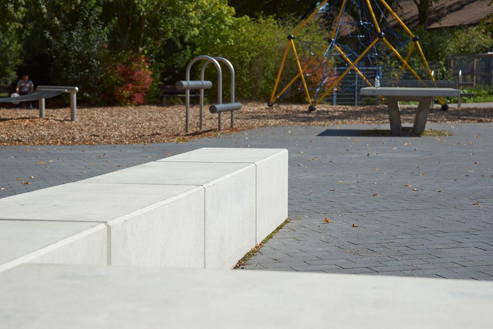 Langer Betonsitzblock an einem Spielplatz