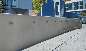 [Translate to Polski:] Glatte Betontrennwand mit Geländer